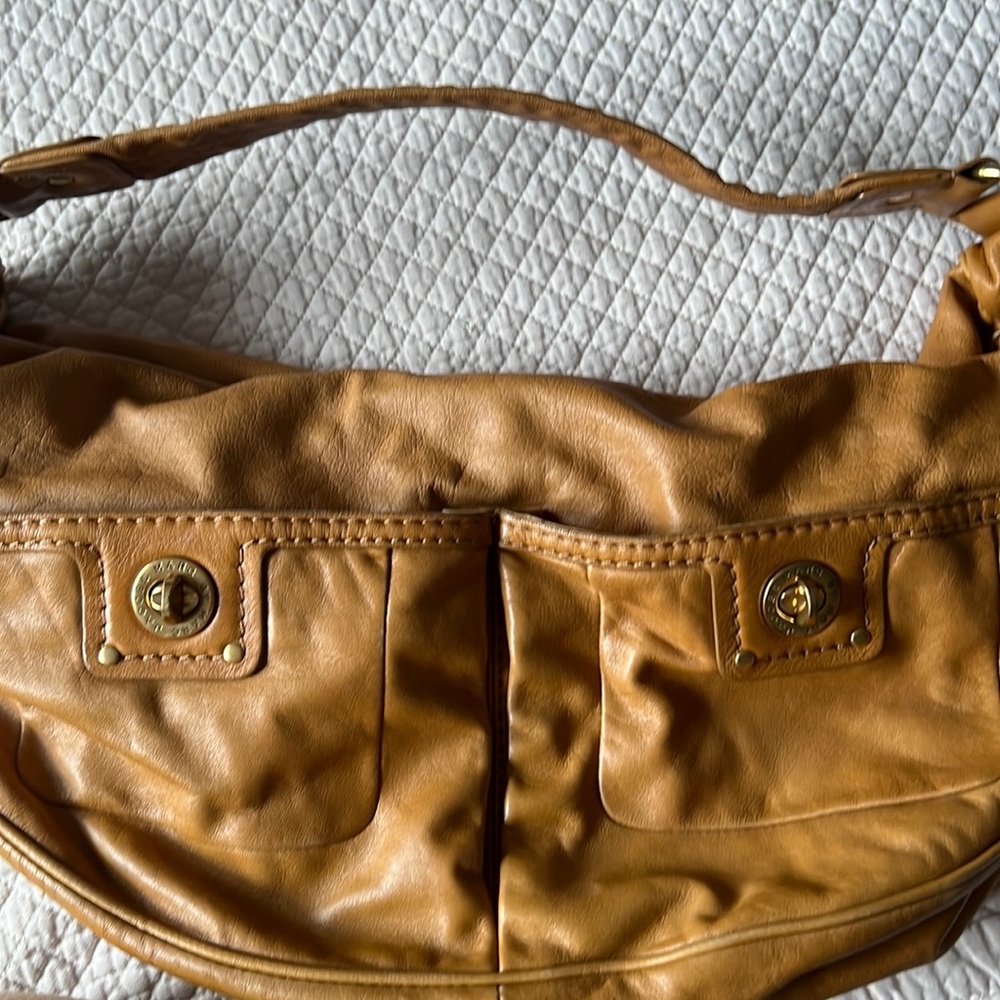 Tan all leather hobo style bag.  2 outside pockets, 1 zippered inside pocket,